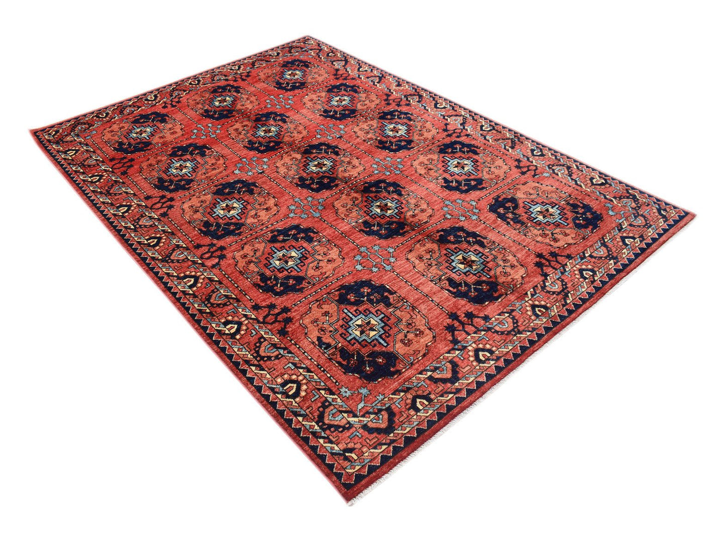 A rectangular Afghan Chobi rug featuring a repeating geometric pattern in shades of red and blue.