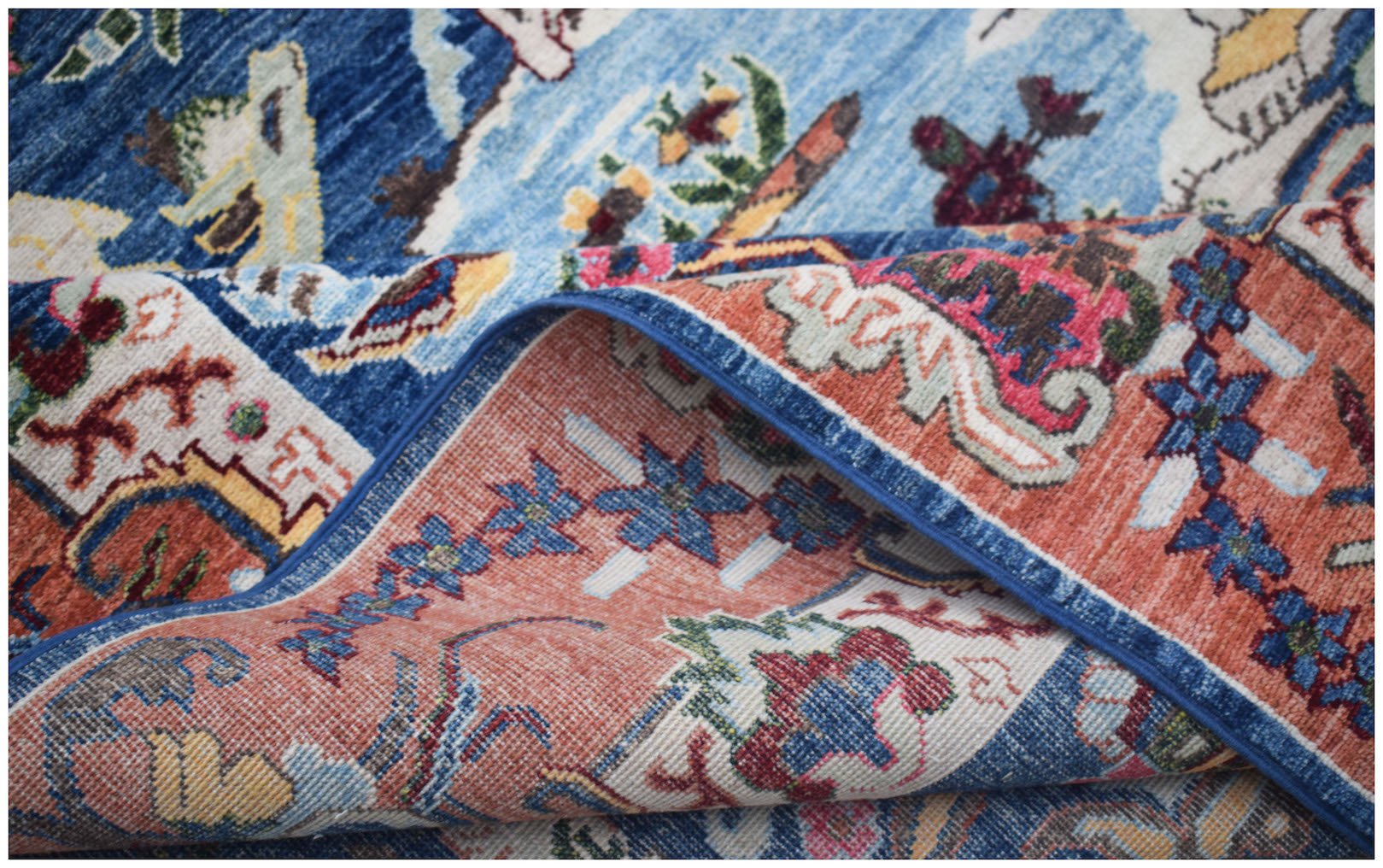 A handwoven Afghan Chobi rug featuring intricate floral patterns in blue, orange, and cream tones.