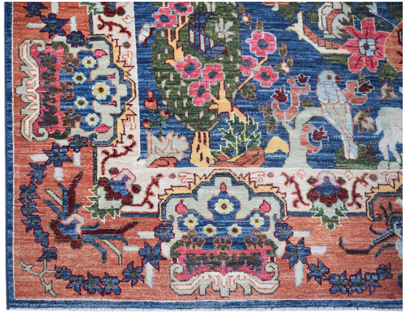 Handwoven Afghan Chobi rug featuring a traditional floral and bird pattern in blue and terracotta.
