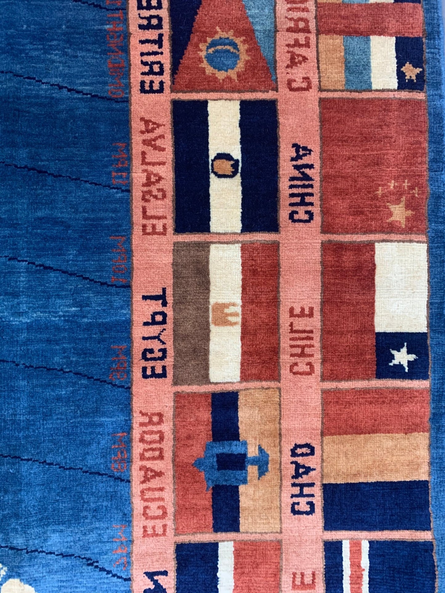 A handmade Afghan Chobi rug featuring a grid of international flags with text labels.
