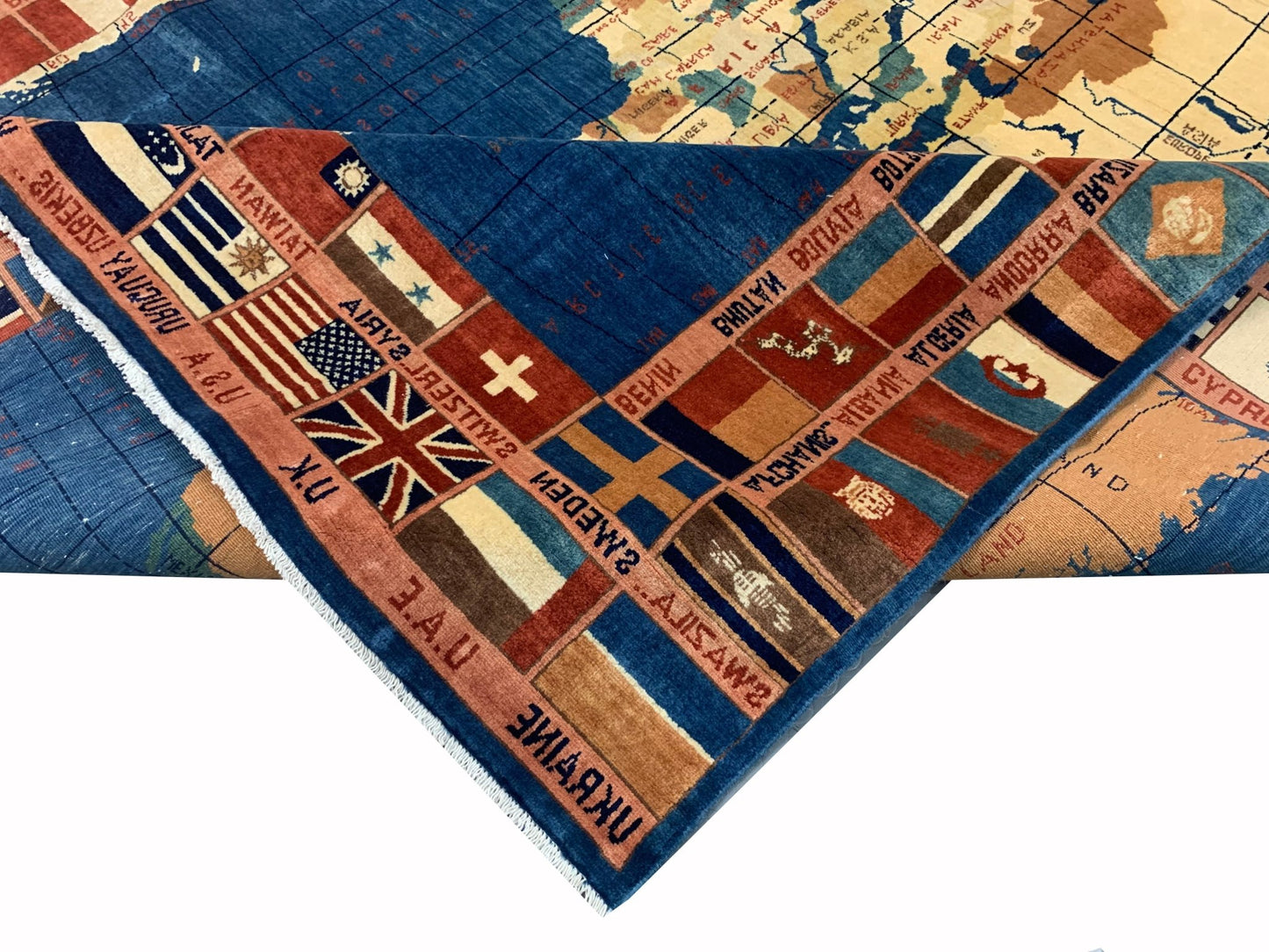A handmade Afghan Chobi rug featuring a world map design with a border of international flags.