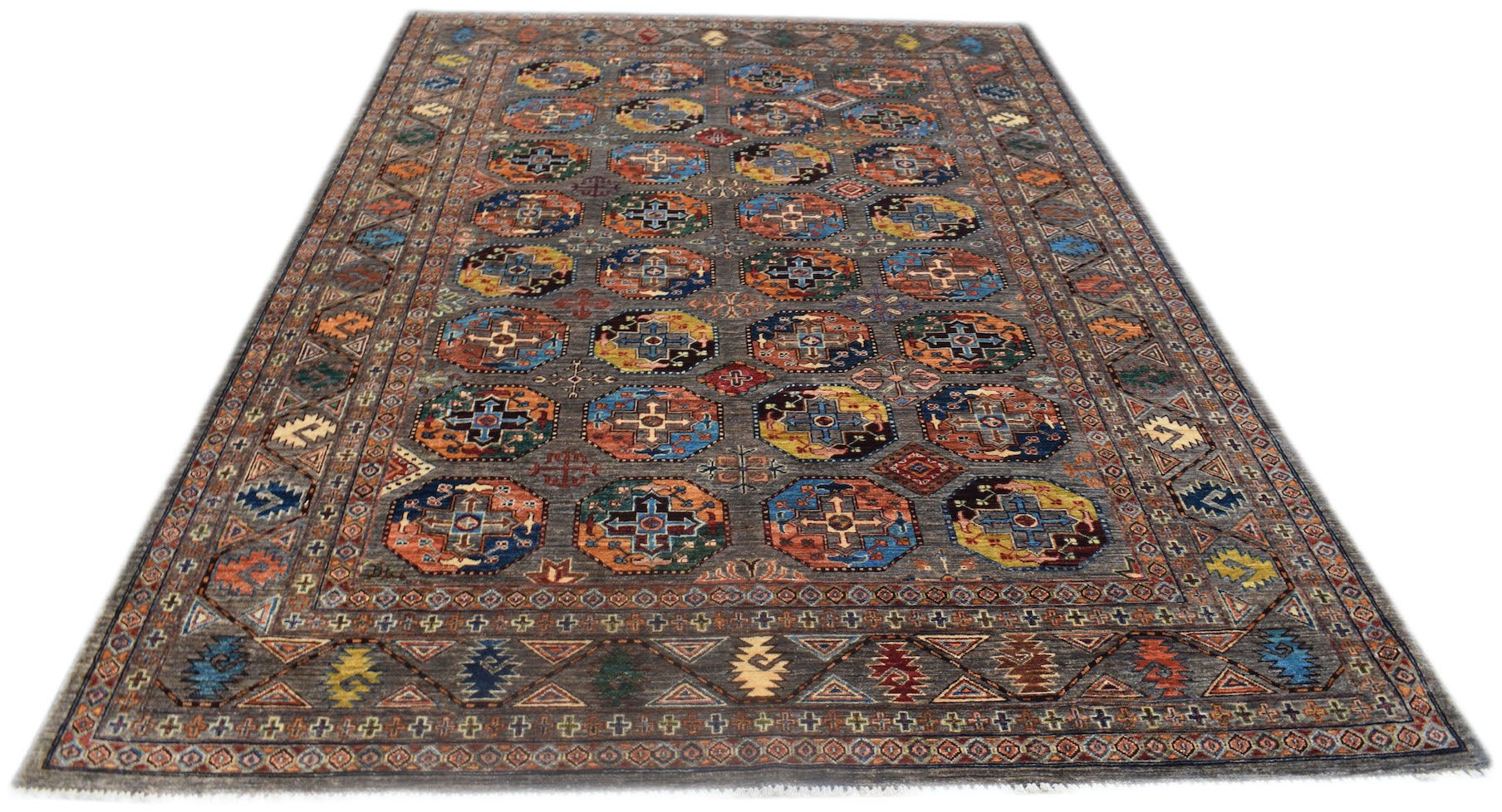 A handmade Afghan Chobi rug featuring a repeating geometric medallion pattern in earthy tones.