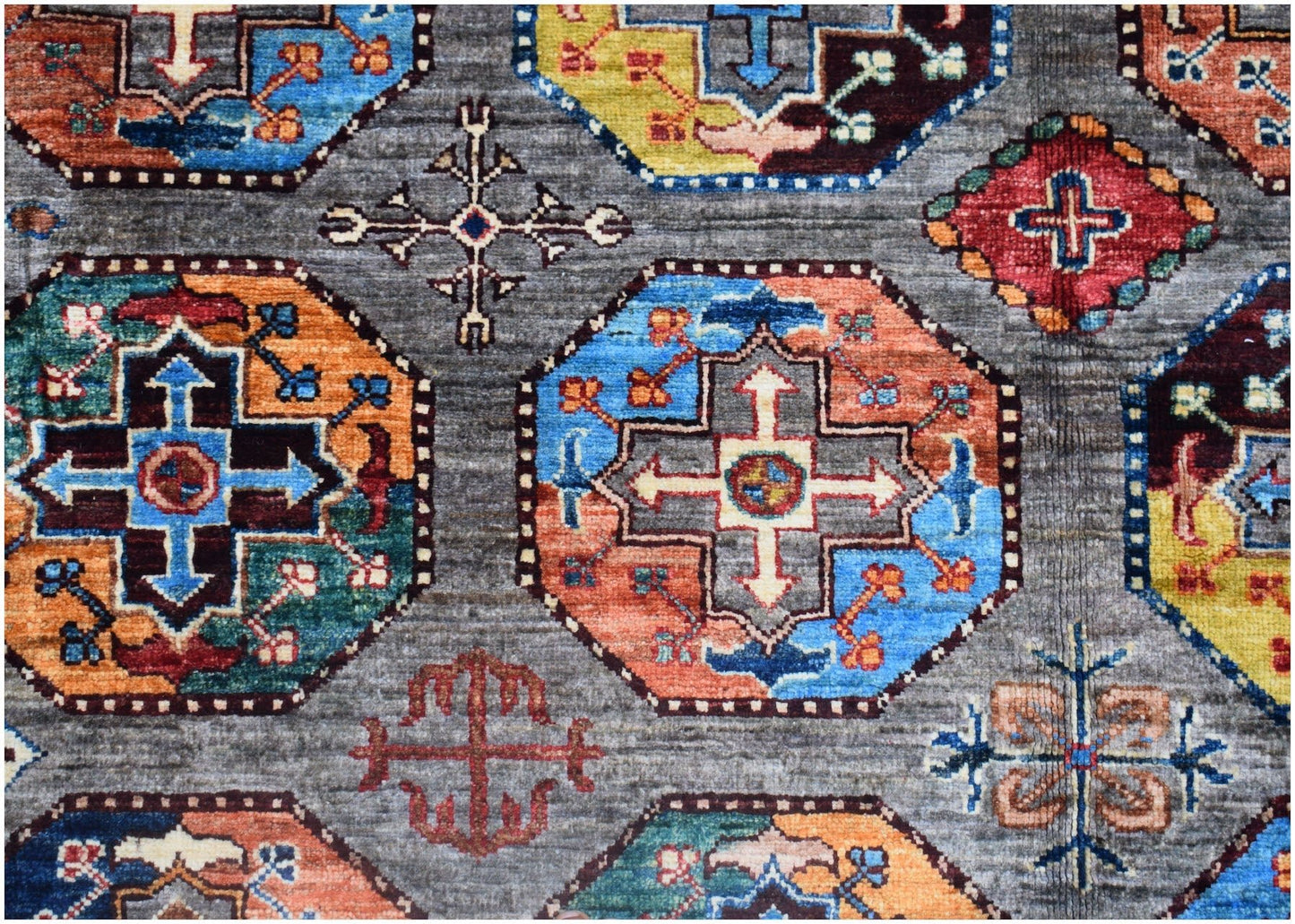 Handmade Afghan Chobi rug featuring a geometric pattern of colorful octagons on a gray background.