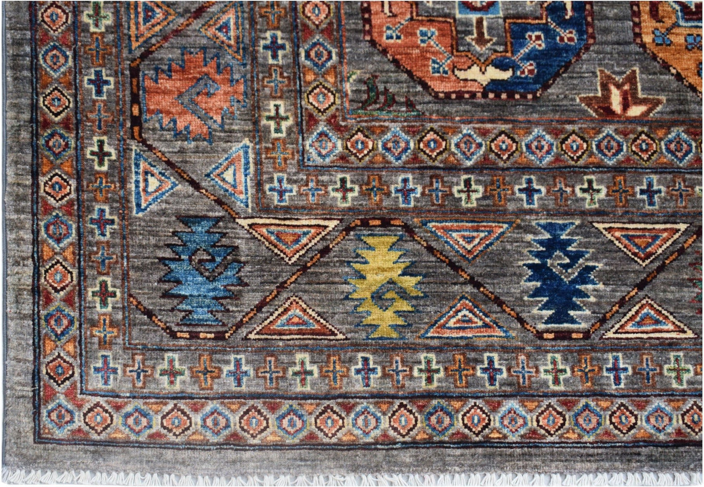 Handmade Afghan Chobi rug featuring a grey field with geometric patterns and a fringed edge.