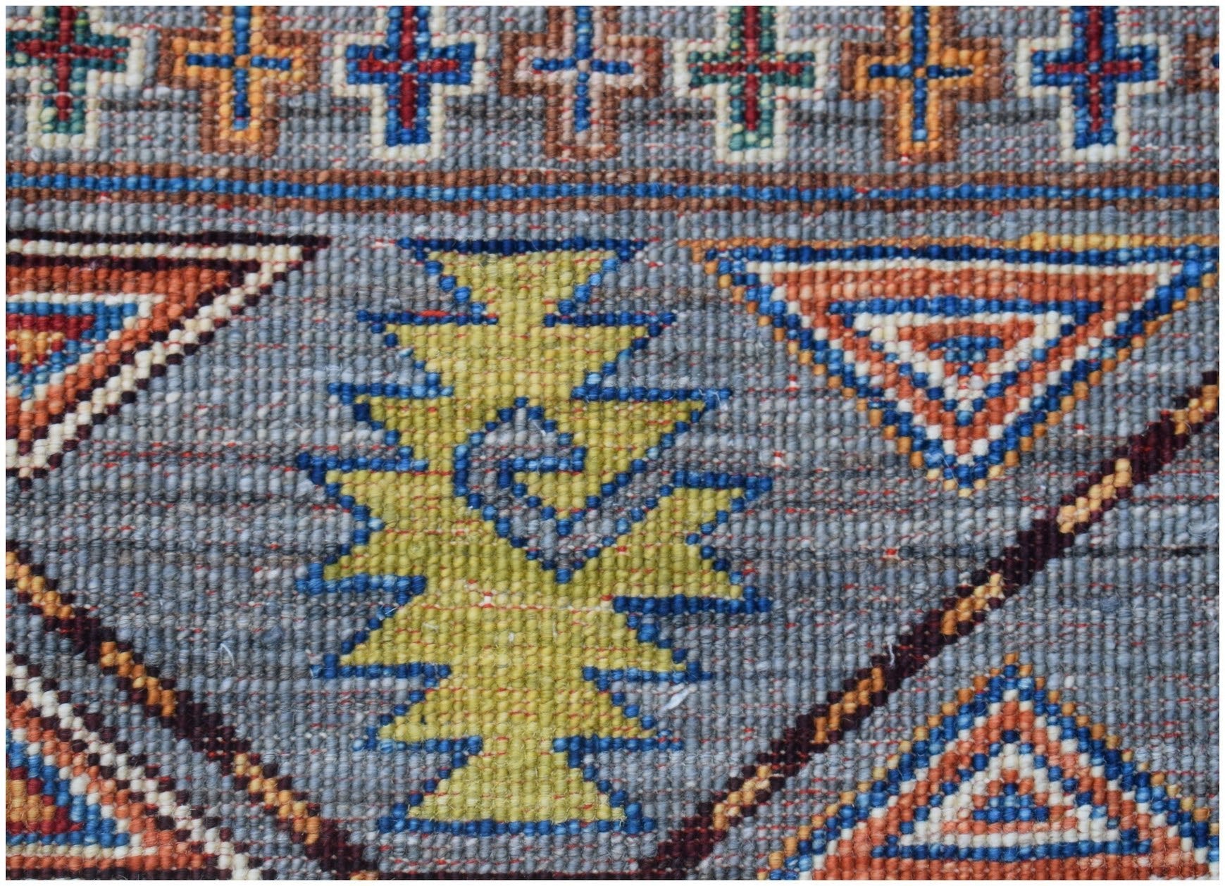 Handmade Afghan Chobi rug featuring a geometric pattern with blue, orange, and yellow motifs.