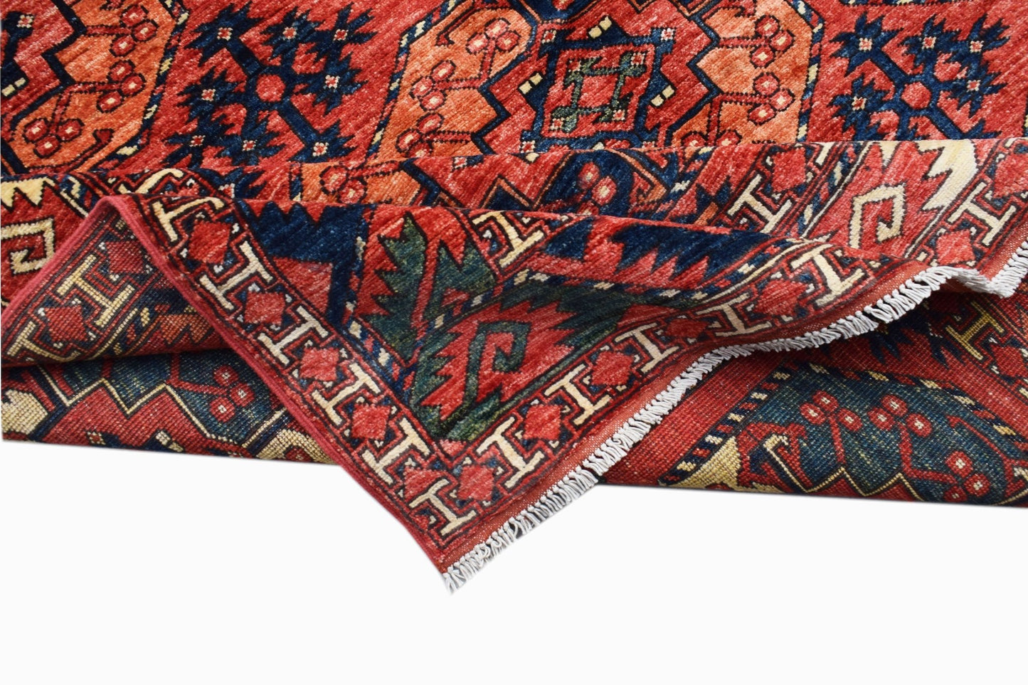 A handmade Afghan Chobi rug featuring traditional geometric patterns in red, blue, and cream.