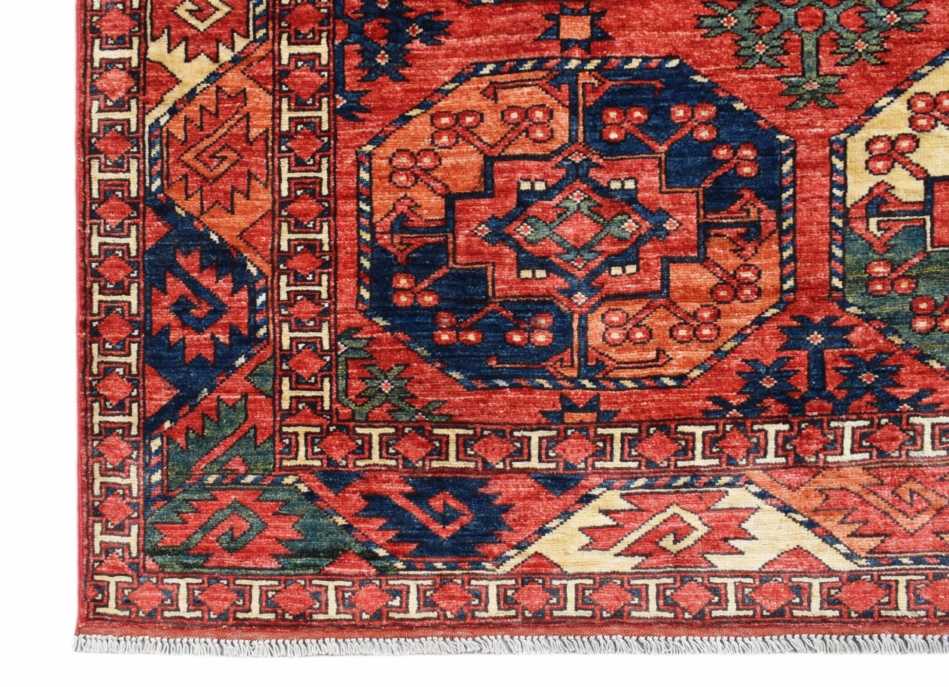 A handmade Afghan Chobi rug featuring a traditional geometric pattern in red, blue, and cream.