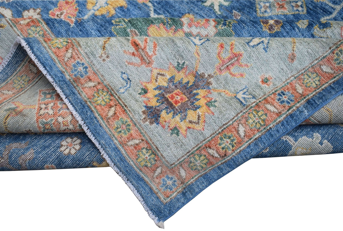 A handmade Afghan Chobi rug featuring a traditional floral pattern in blue, orange, and yellow.