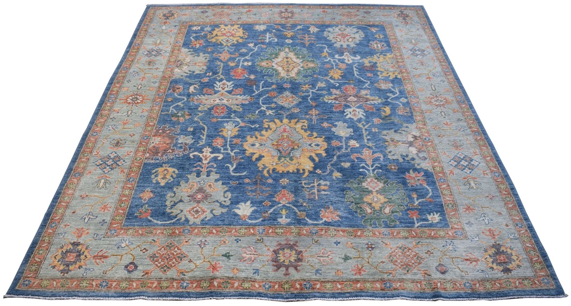 A handmade Afghan Chobi rug featuring a traditional floral pattern in blue and earthy tones.