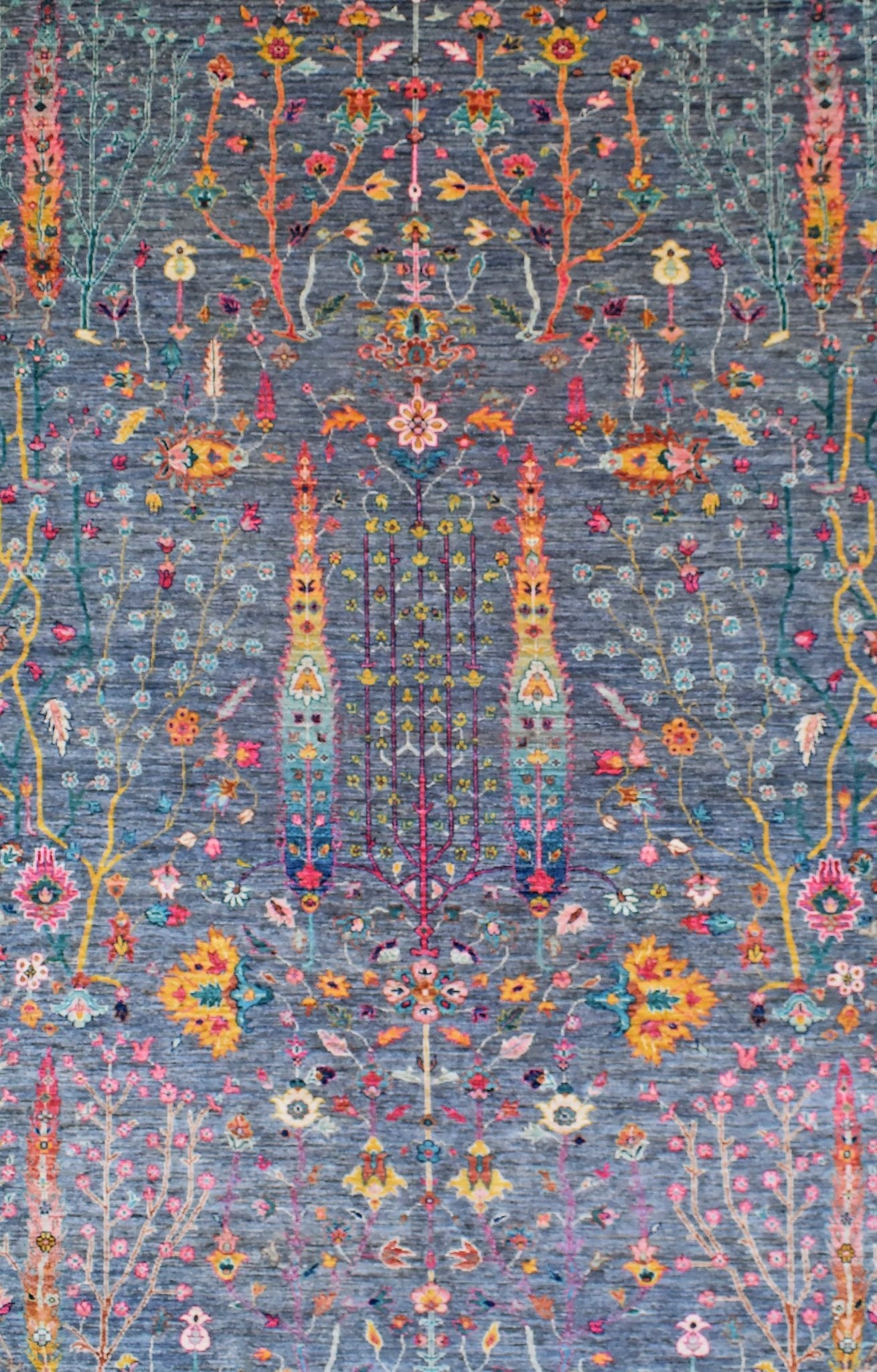 A handmade Afghan Chobi rug featuring a floral pattern in vibrant colors on a blue background.