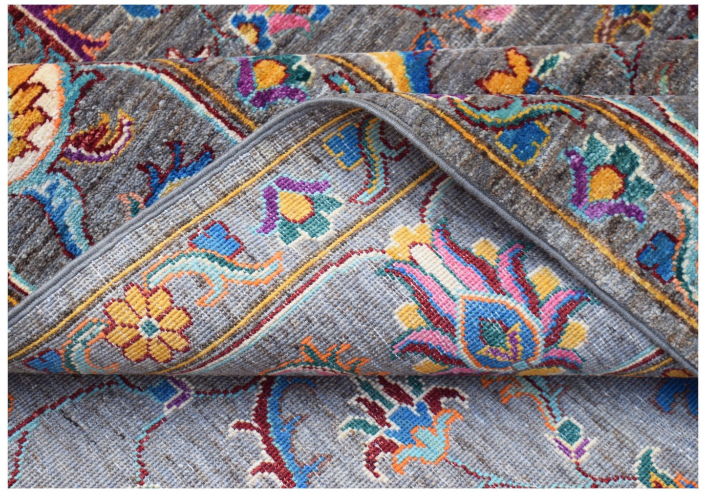 A handwoven Afghan Chobi rug featuring a traditional floral pattern in vibrant, multi-colored wool.