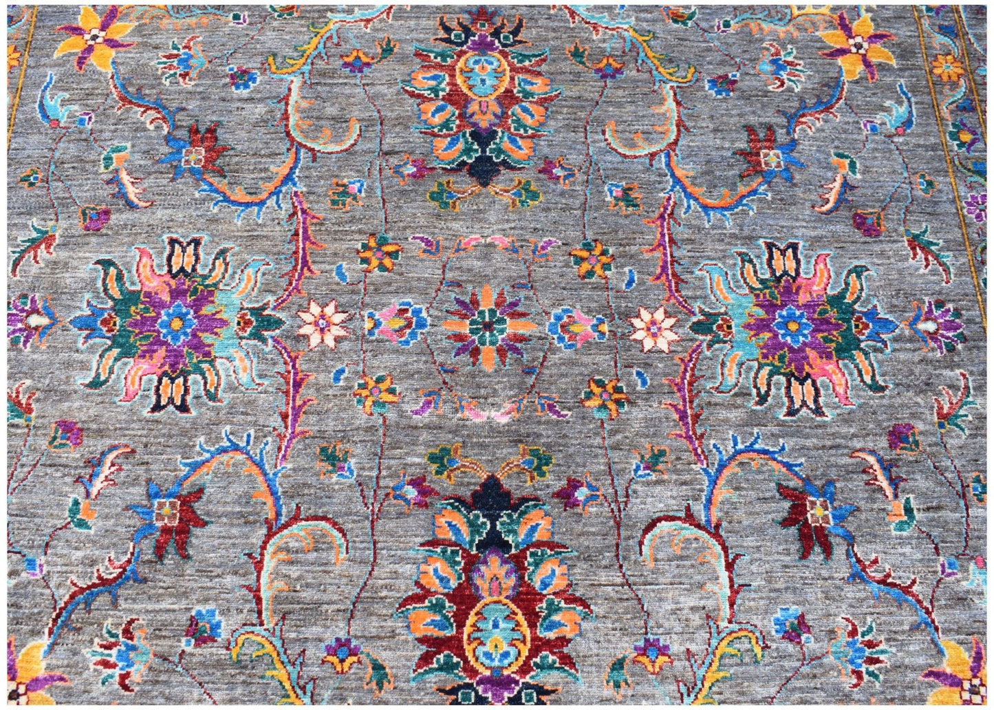 Handwoven Afghan Chobi rug featuring a traditional floral pattern in vibrant colors on a gray base.