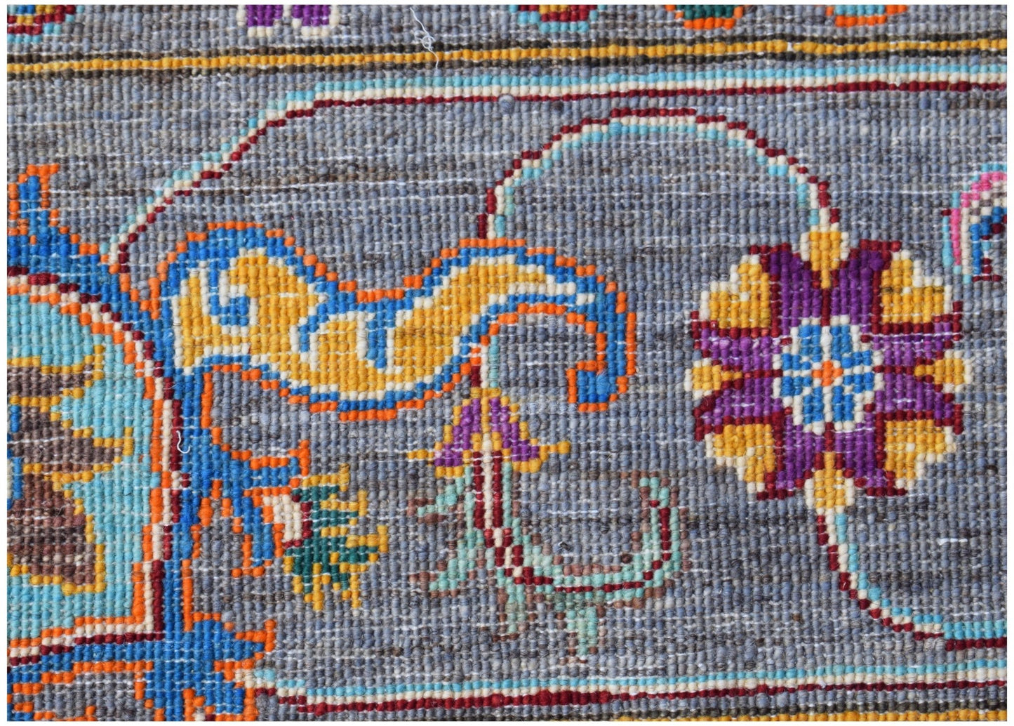 A close-up of a handwoven Afghan Chobi rug featuring intricate floral patterns in vibrant colors.