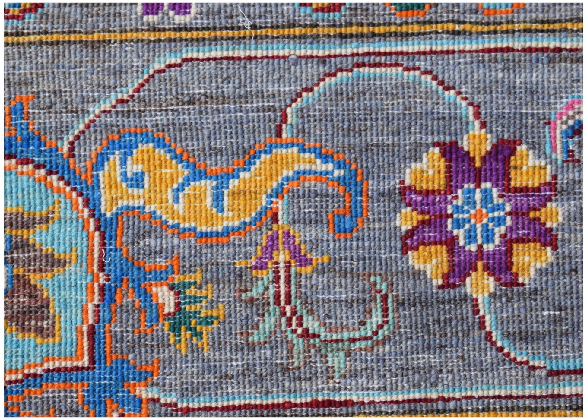 A close-up of a handwoven Afghan Chobi rug featuring intricate floral patterns in vibrant colors.