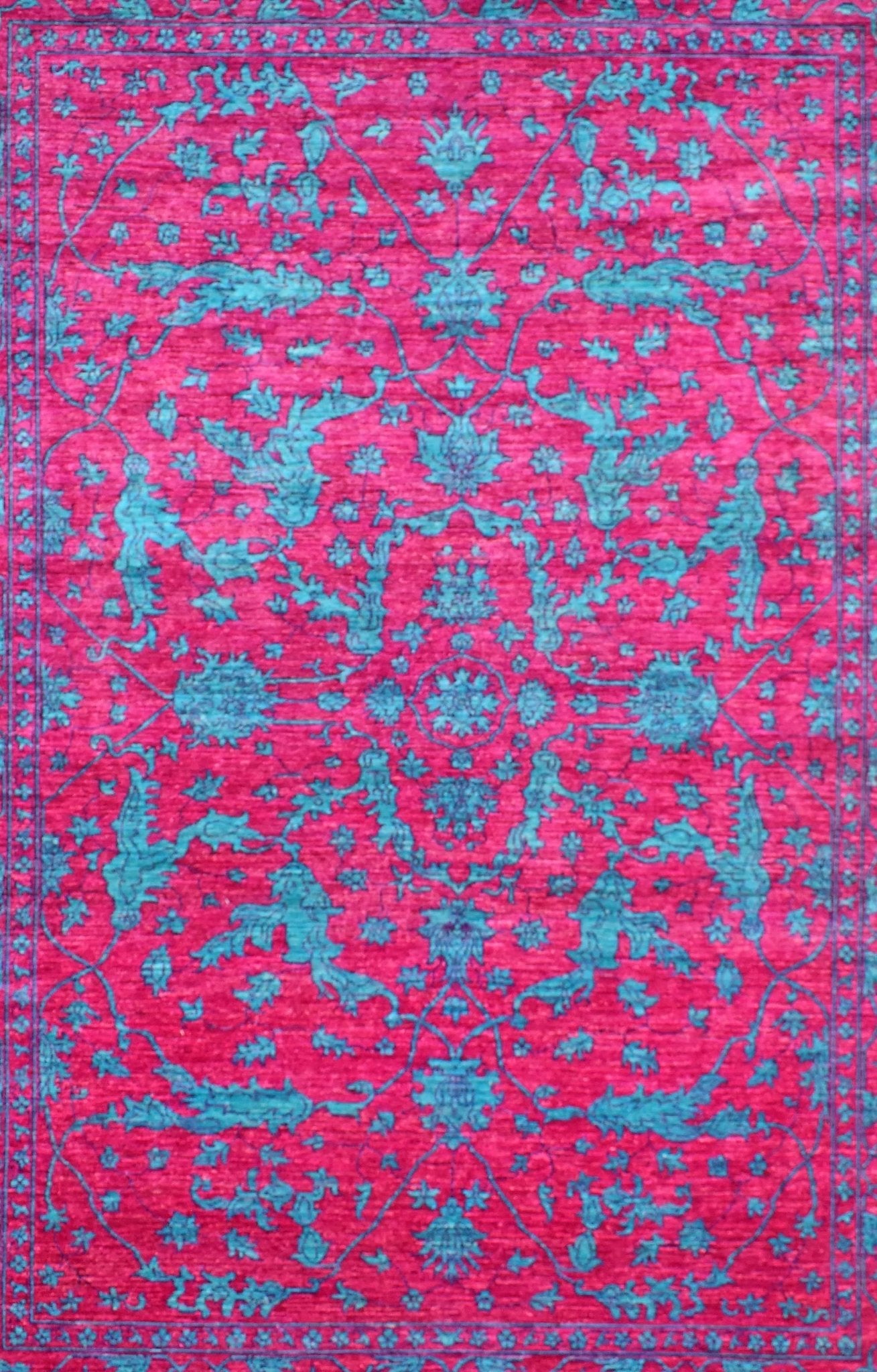 A rectangular Afghan Chobi rug featuring a vibrant magenta field with intricate teal floral motifs.