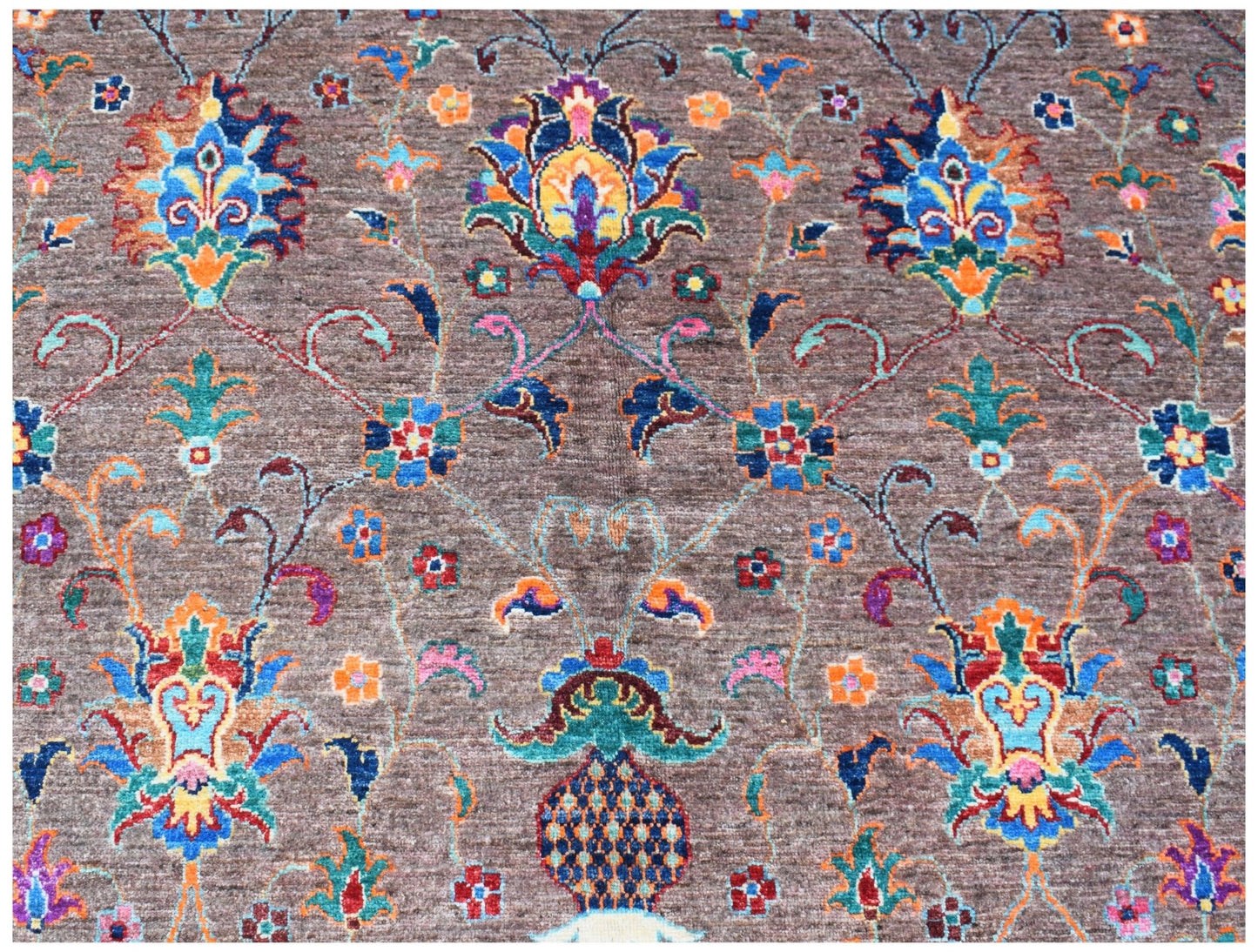 An Afghan Chobi rug featuring a traditional floral pattern in vibrant colors on a brown background.
