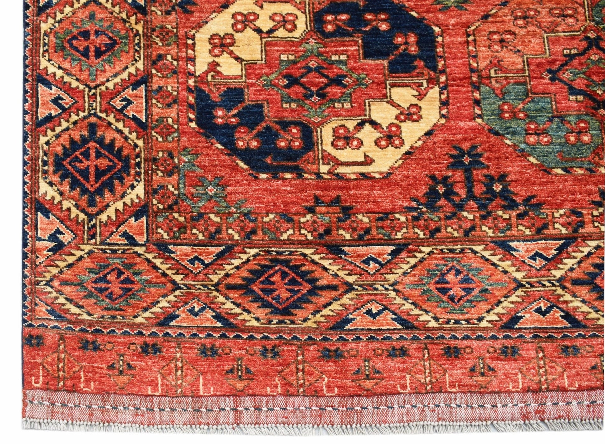 A handwoven Afghan Chobi rug featuring traditional geometric patterns in red, blue, and cream.