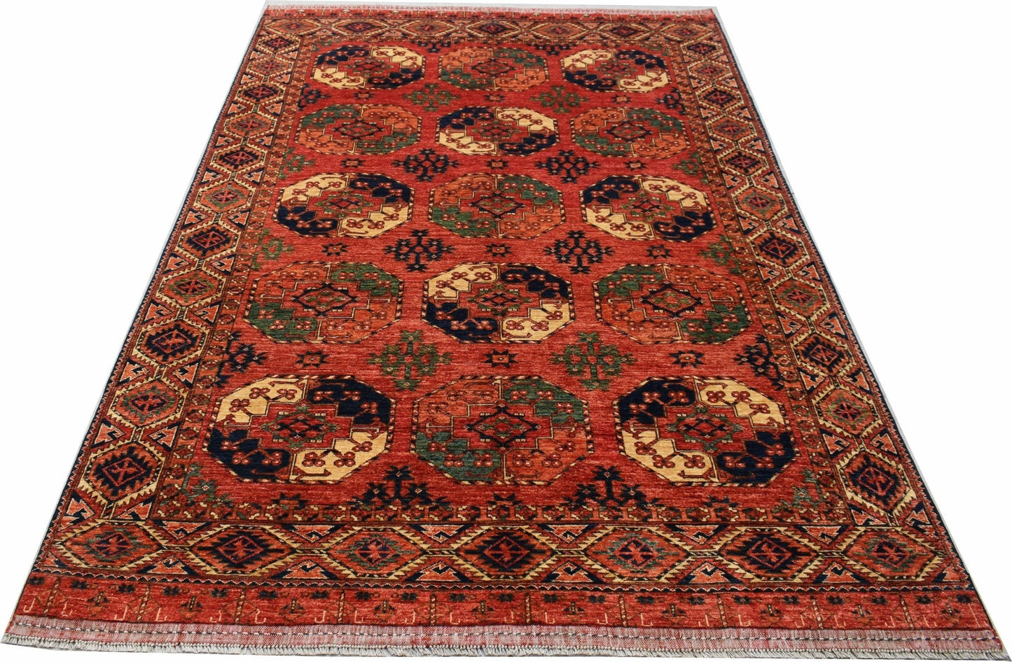 A handmade Afghan Chobi rug featuring a repeating octagonal pattern in warm, earthy tones.