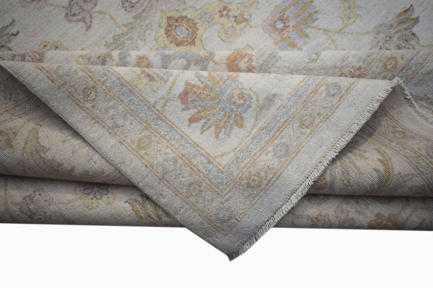 A folded Afghan Chobi rug featuring a traditional floral pattern in soft, earthy tones.