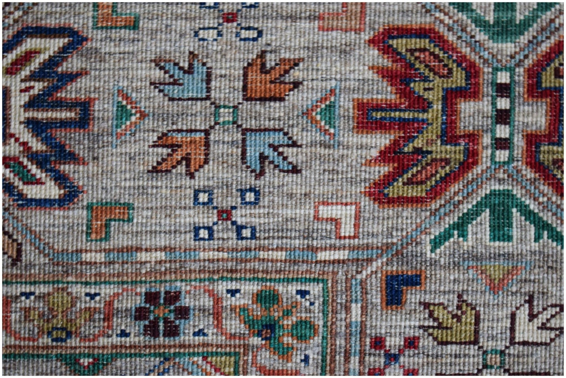 A handwoven Afghan Chobi rug featuring intricate geometric patterns in earthy, multi-colored tones.