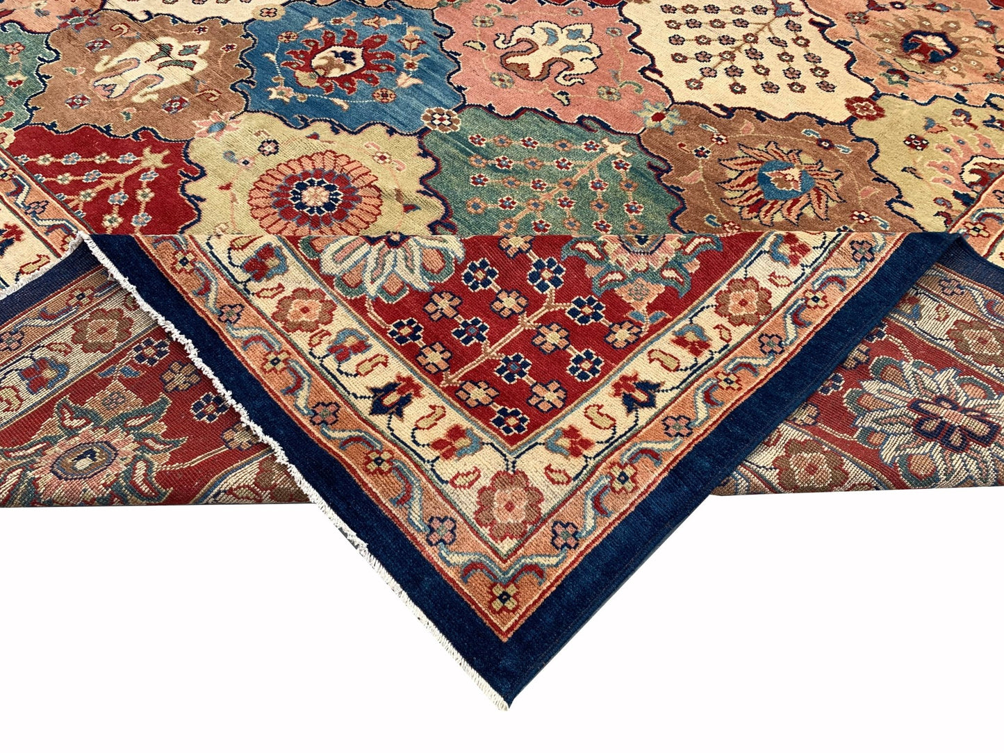 A handmade Afghan Chobi rug featuring a colorful geometric pattern with a folded corner.