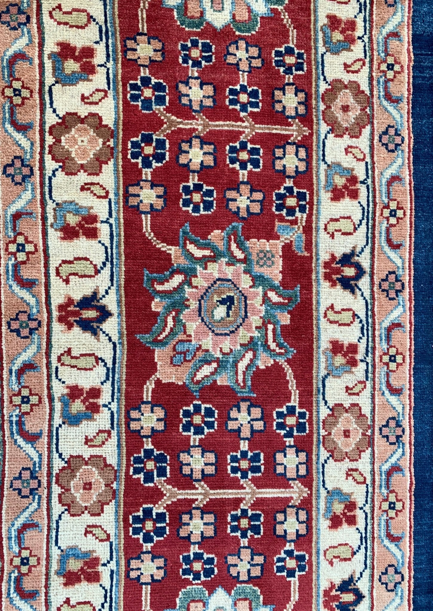 A handmade Afghan Chobi rug featuring a red field with floral motifs and intricate borders.