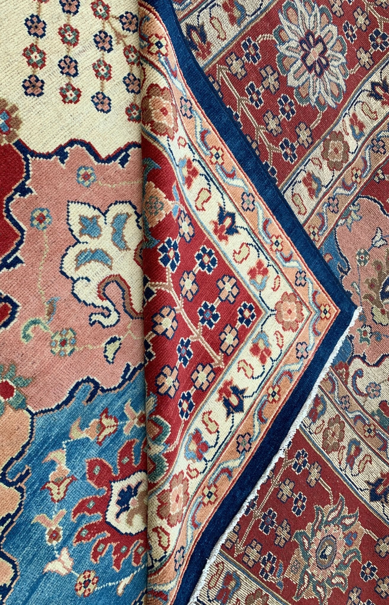 A handmade Afghan Chobi rug featuring intricate floral patterns in red, blue, and cream tones.