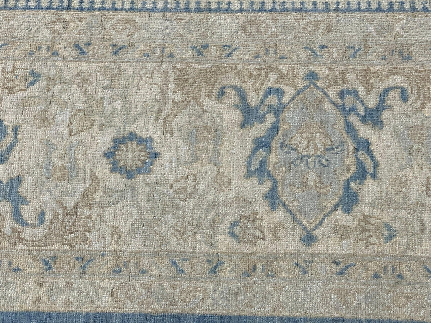 A handmade Afghan Chobi rug featuring a traditional blue and beige floral medallion pattern.