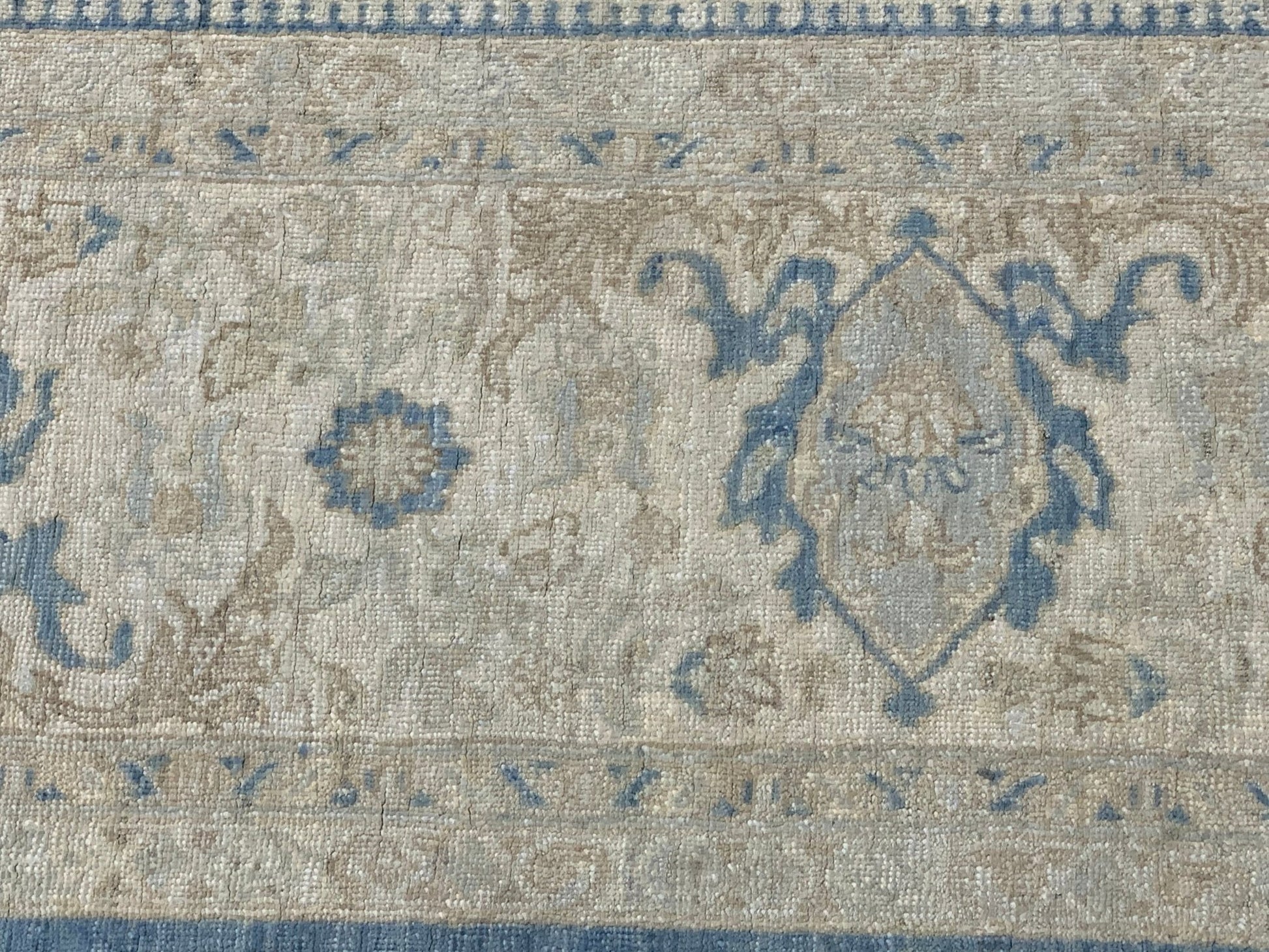 A handmade Afghan Chobi rug featuring a traditional blue and beige floral medallion pattern.
