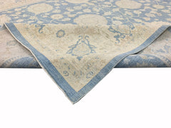 A handmade Afghan Chobi rug featuring a traditional floral pattern in soft blue and beige tones.
