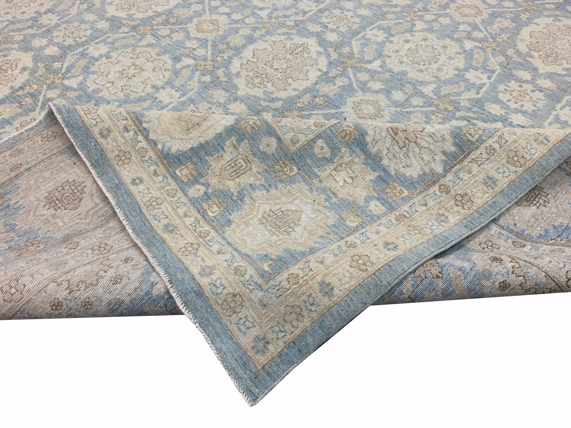 A handmade Afghan Chobi rug featuring a traditional floral pattern in soft blue and beige tones.