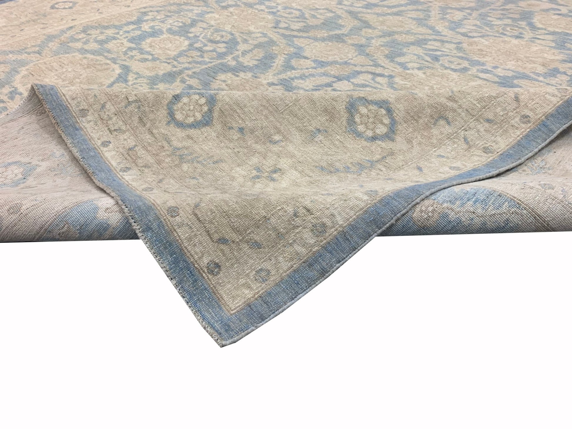 A handmade Afghan Chobi rug featuring a traditional floral pattern in soft blue and beige tones.