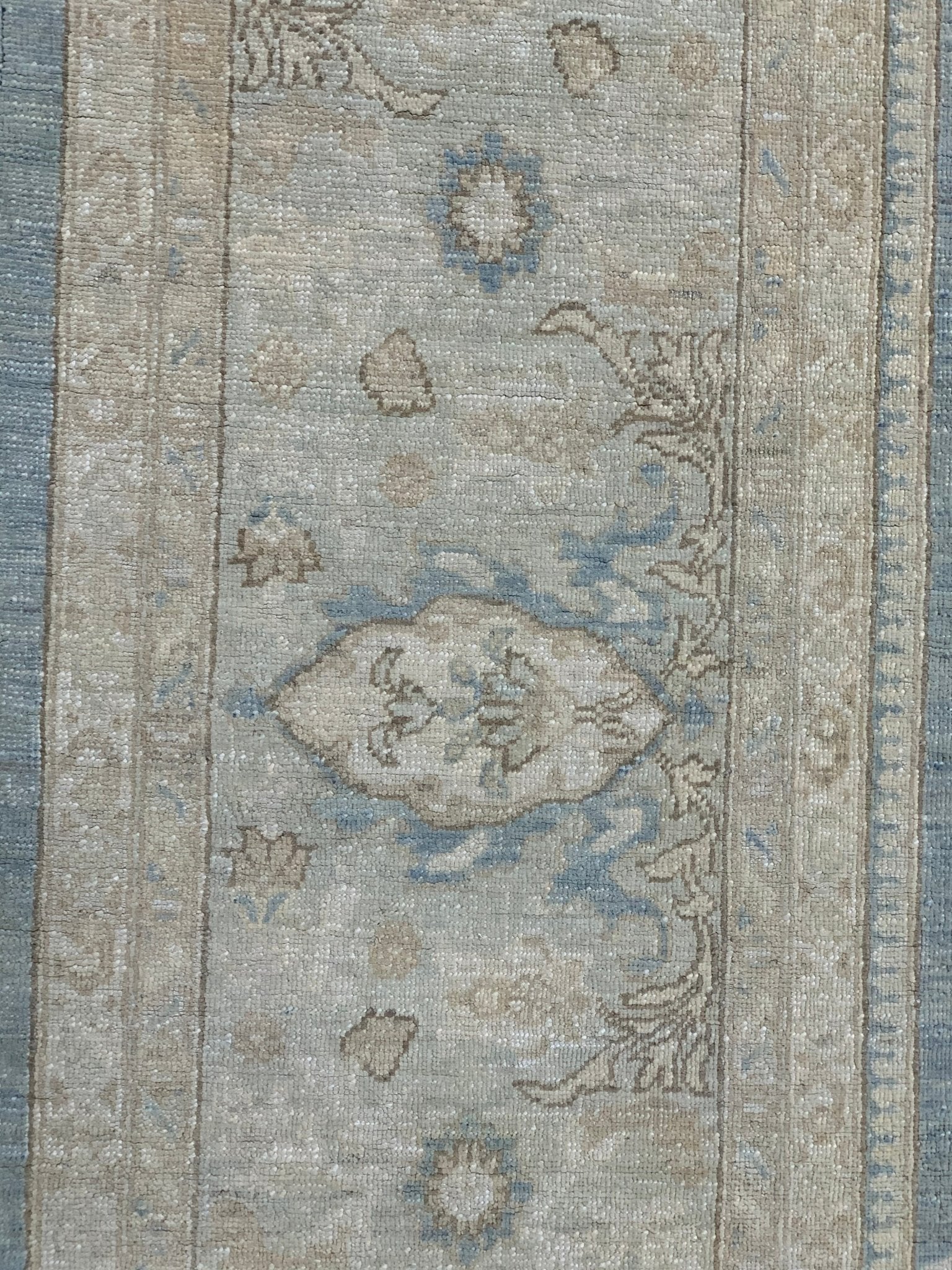 Handmade Afghan Chobi rug featuring a traditional floral pattern in soft blue and beige tones.