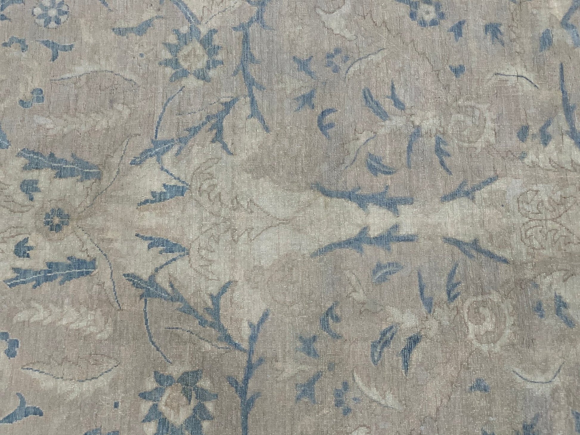 A handmade Afghan Balkh rug featuring a traditional floral pattern in muted blue and beige tones.