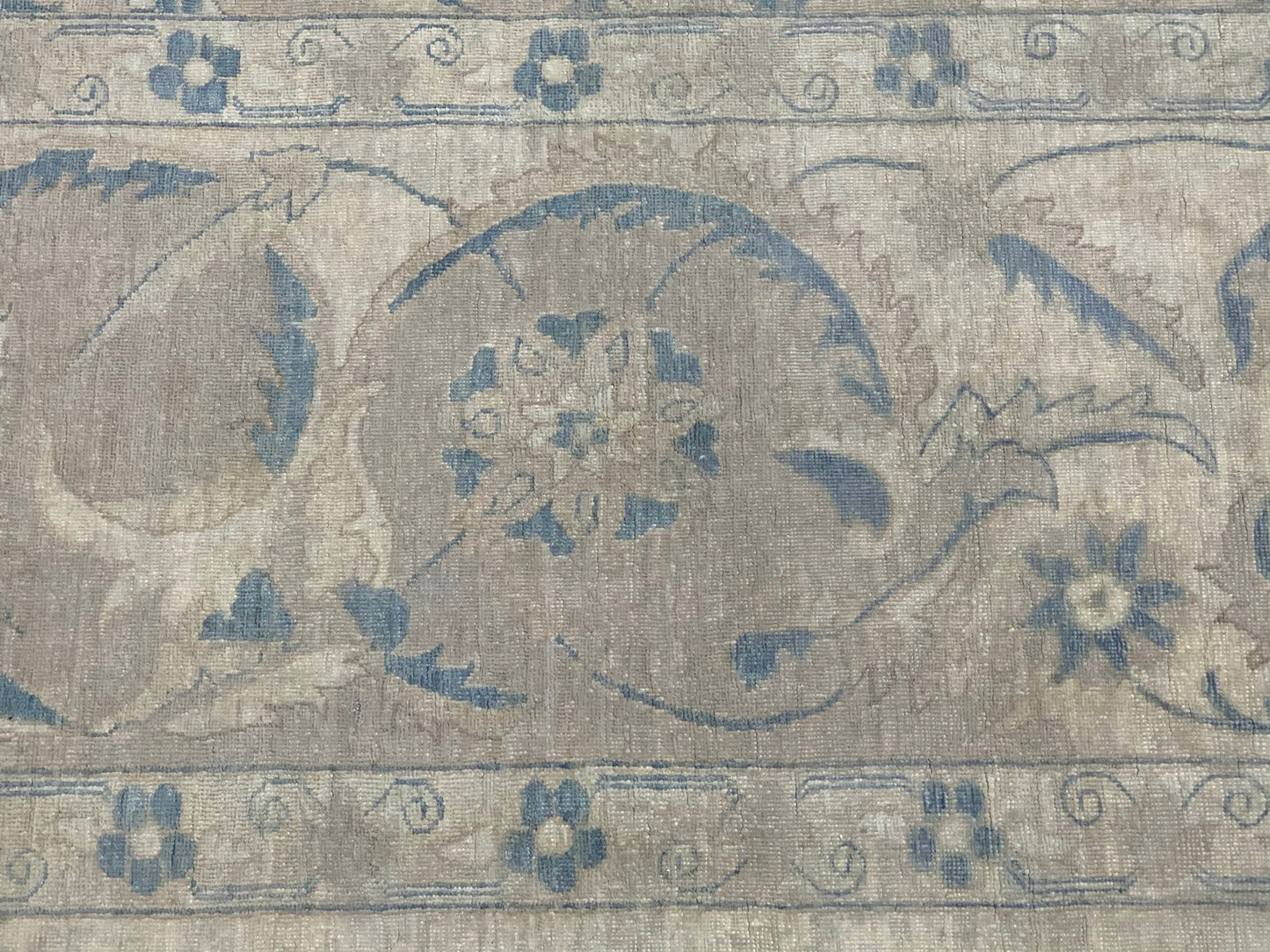 A handmade Afghan Balkh rug featuring a traditional floral pattern in muted blue and beige tones.