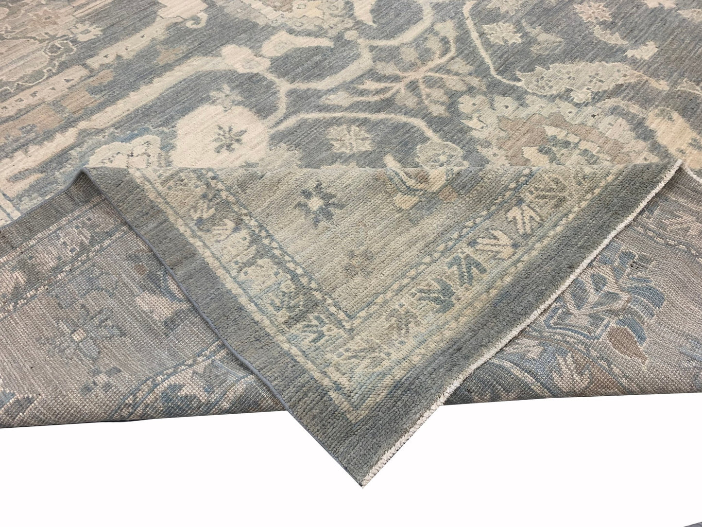 A handmade Afghan Chobi rug featuring a traditional floral pattern in shades of blue and beige.