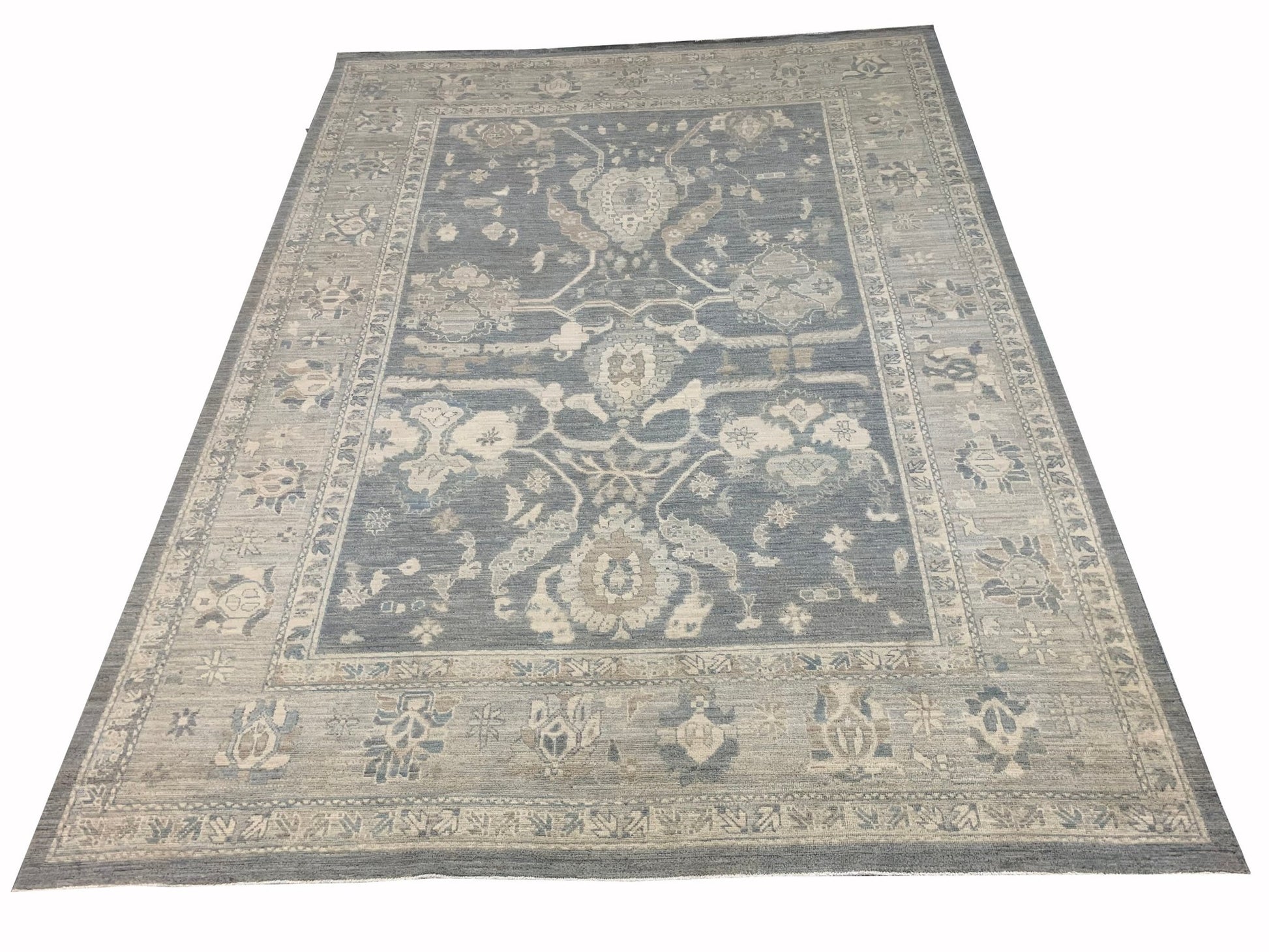 A handmade Afghan Chobi rug featuring a traditional floral pattern in shades of blue and beige.
