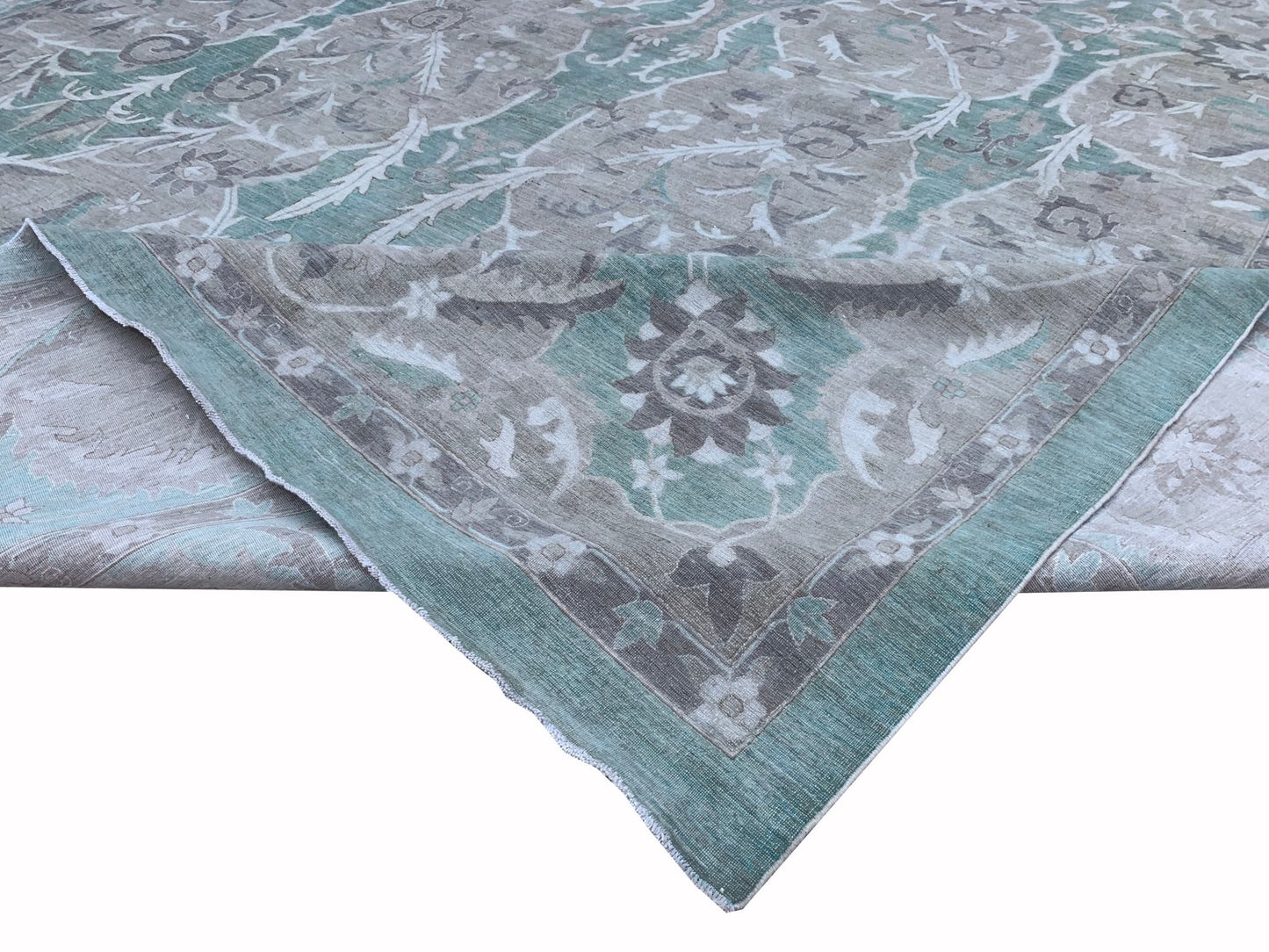 An Afghan Chobi rug featuring a traditional floral pattern in shades of teal, grey, and cream.