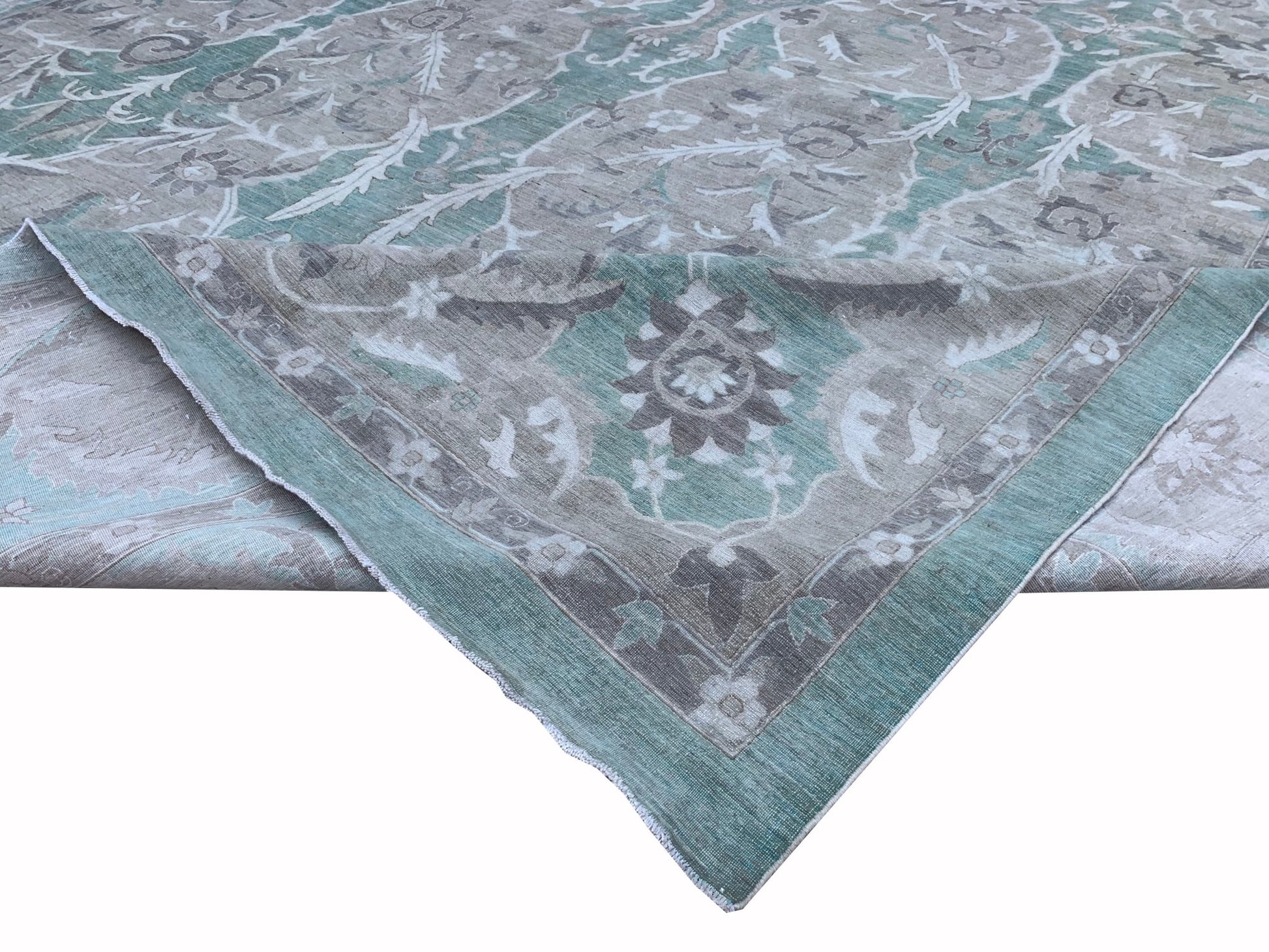 An Afghan Chobi rug featuring a traditional floral pattern in shades of teal, grey, and cream.
