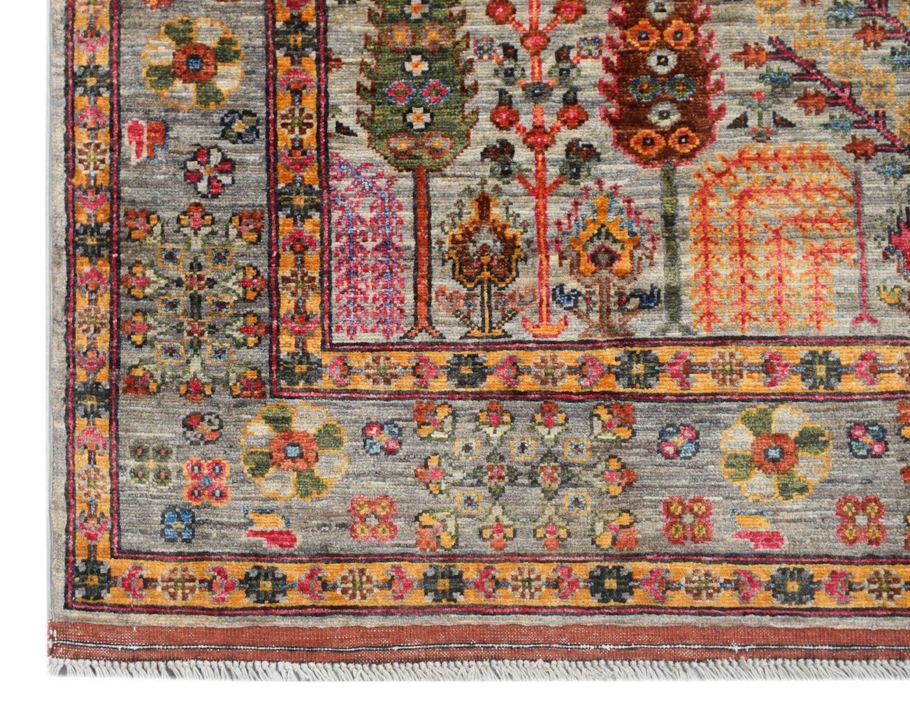 A handwoven Afghan Chobi rug featuring a colorful Tree of Life pattern on a grey wool background.