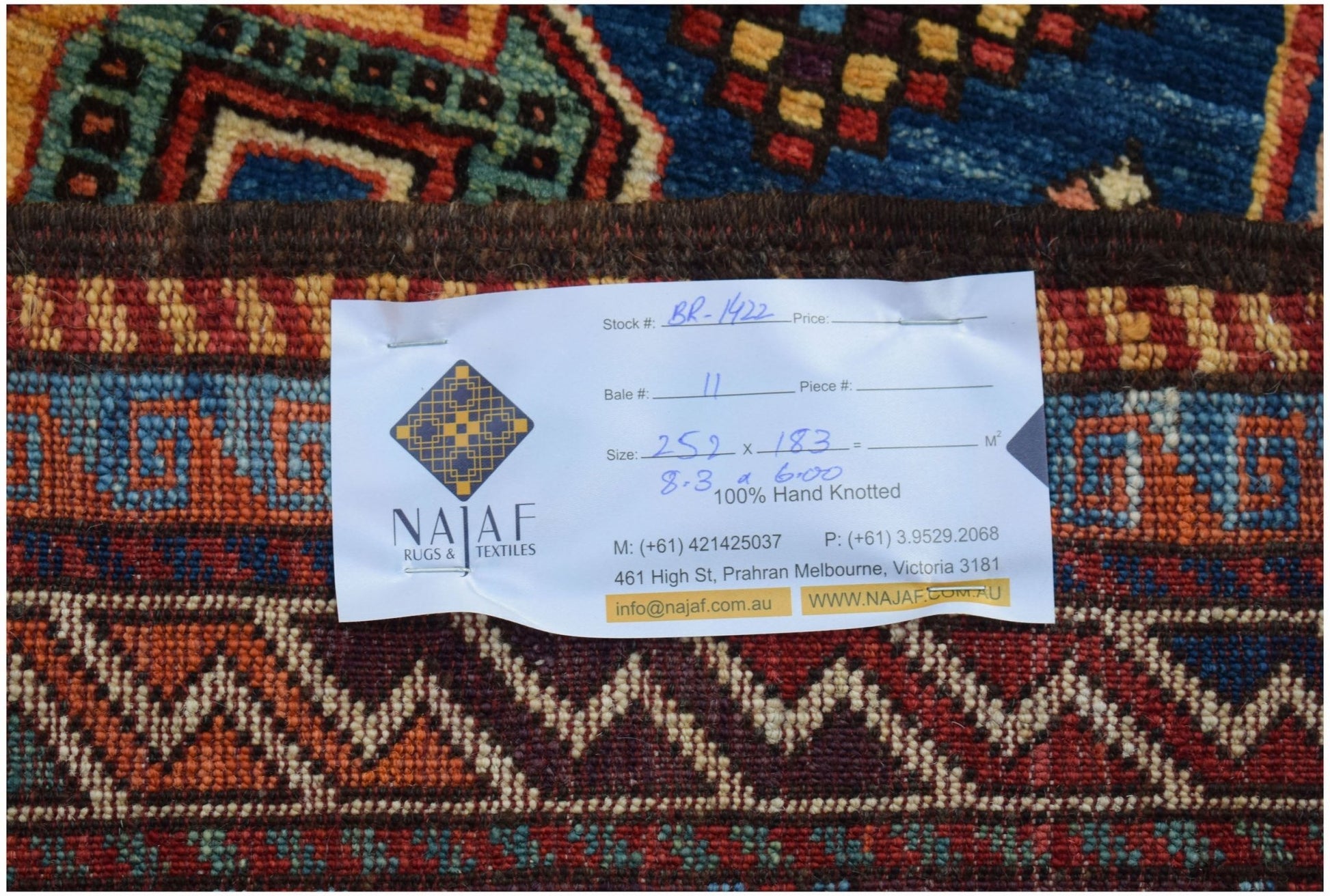 A close-up view of a hand-knotted Afghan Herati rug featuring intricate geometric patterns.