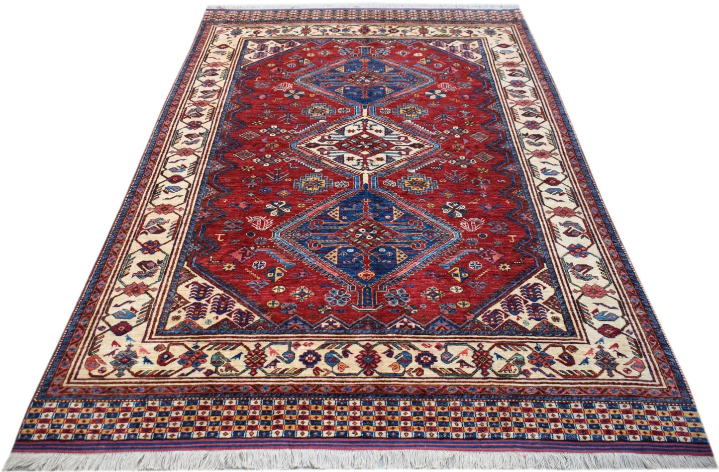 Handwoven Afghan Herati rug featuring a red field with blue diamond medallions and cream borders.