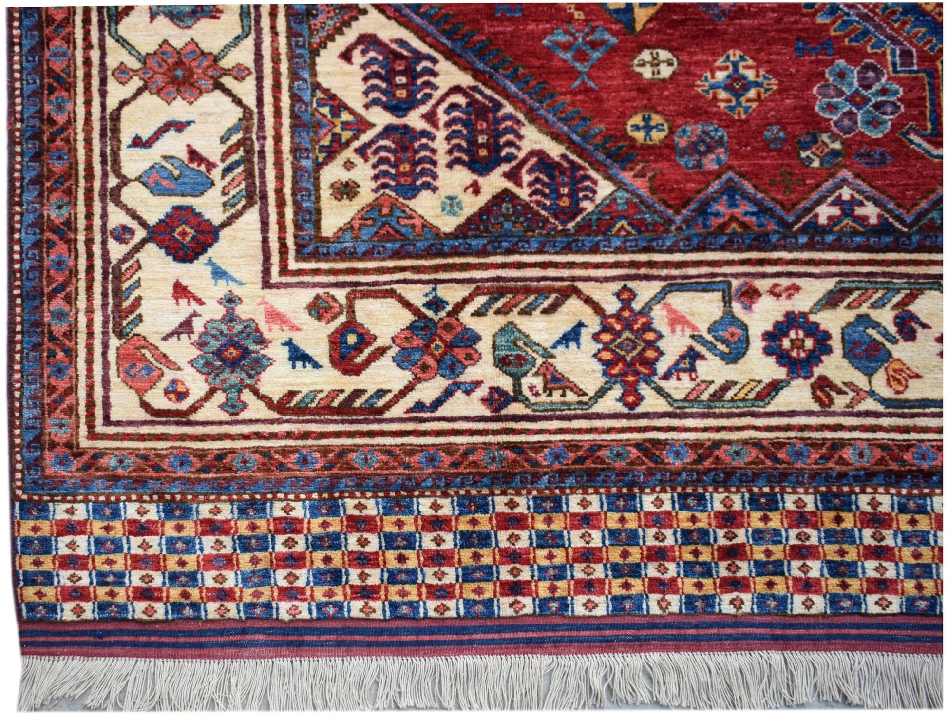 A handmade Afghan Herati rug featuring intricate geometric patterns in red, blue, and cream.
