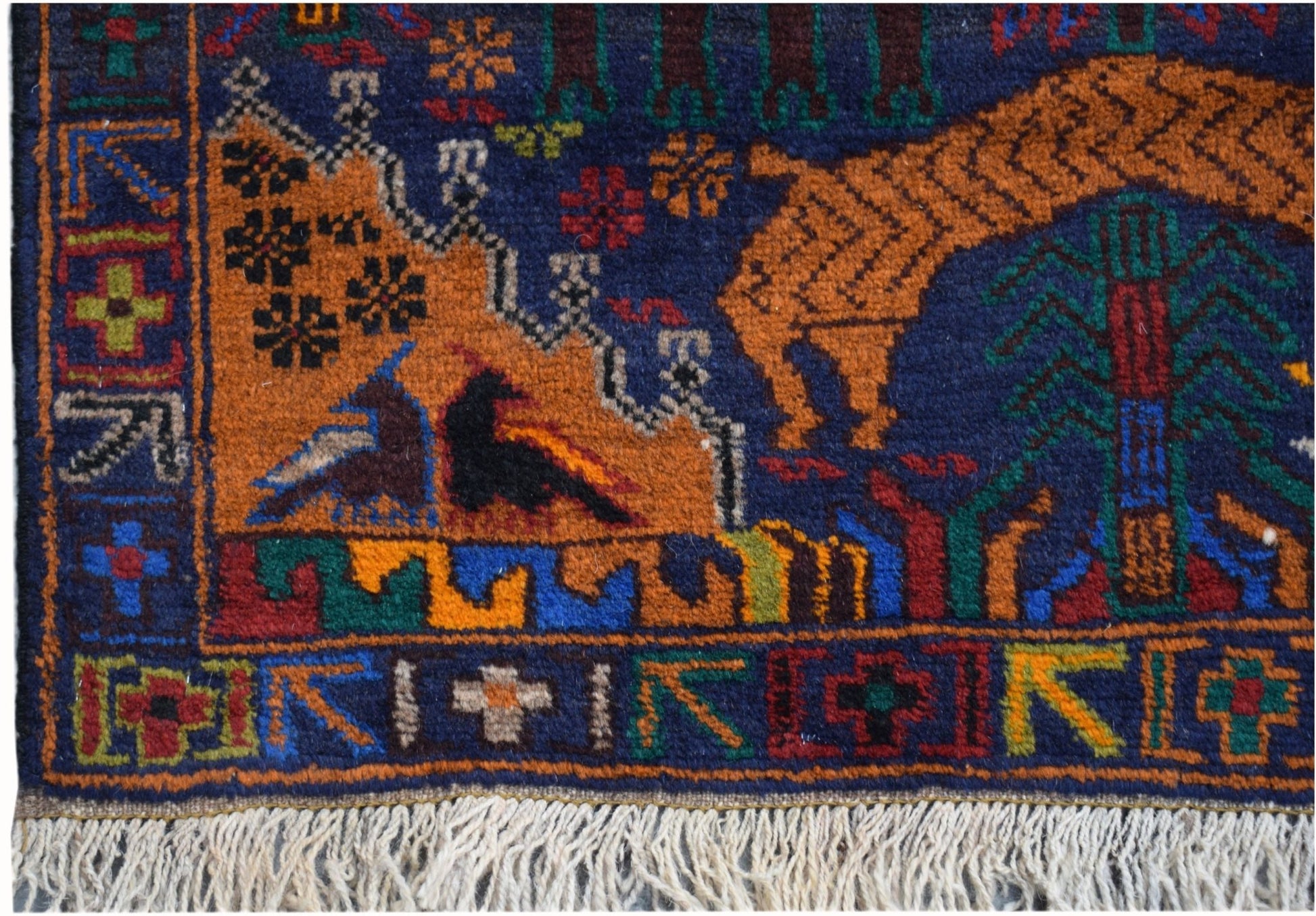 Handmade Afghan wool runner featuring a colorful hunting scene with animals and geometric borders.