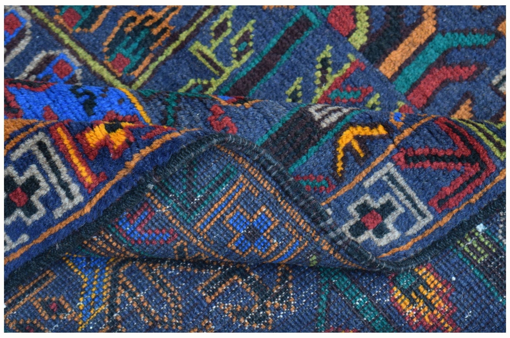 A handmade Afghan wool runner featuring a blue background with intricate geometric hunting motifs.
