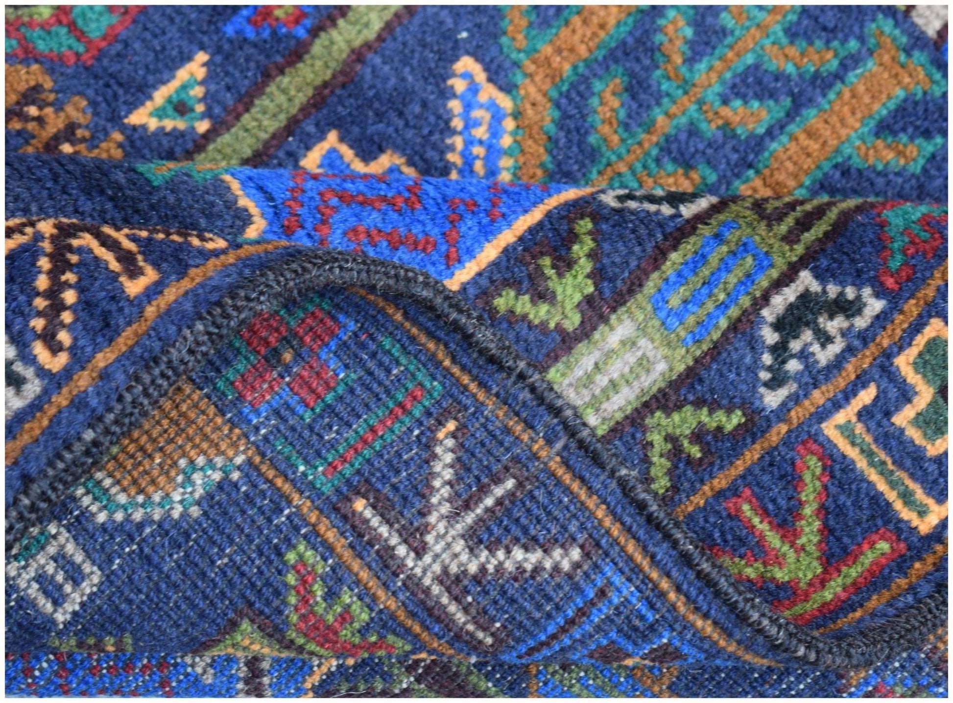 A close-up of a handmade Afghan wool runner featuring a blue background with intricate patterns.