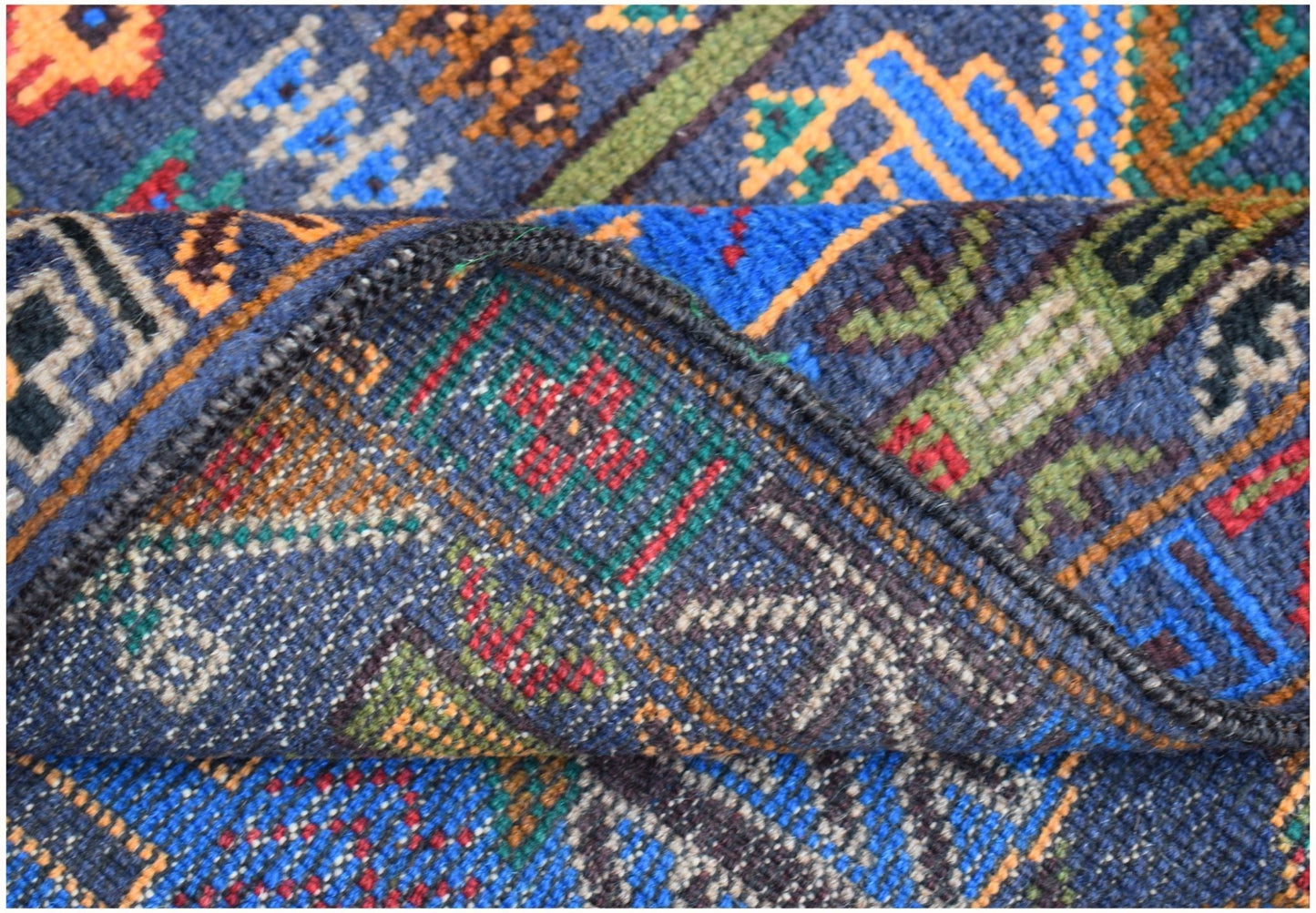 A handmade Afghan wool runner featuring a blue background with intricate geometric hunting motifs.
