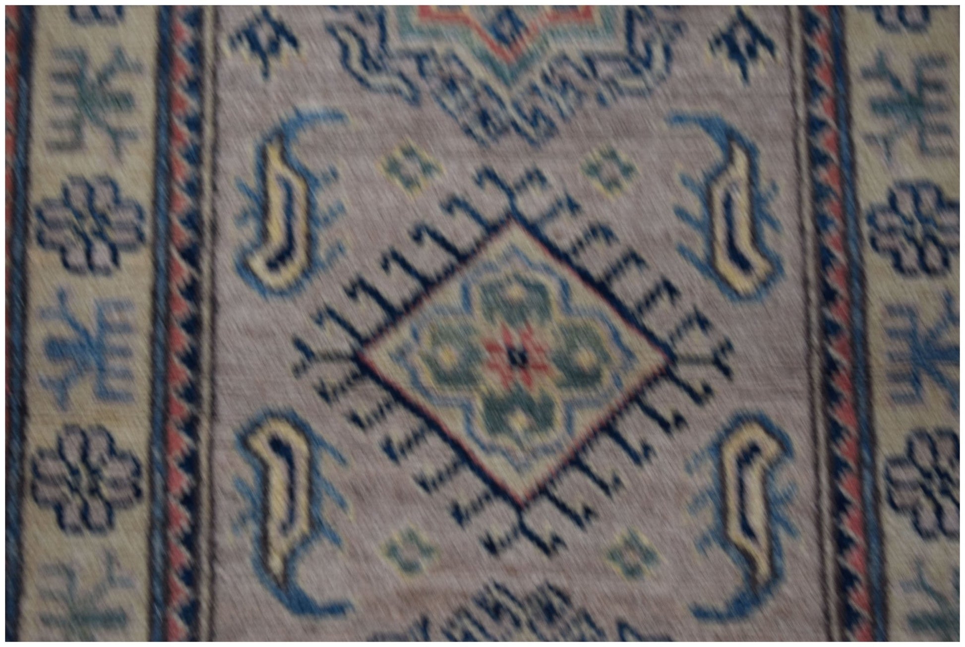 A handmade Afghan Kazakh runner featuring traditional geometric motifs in blue, green, and red.