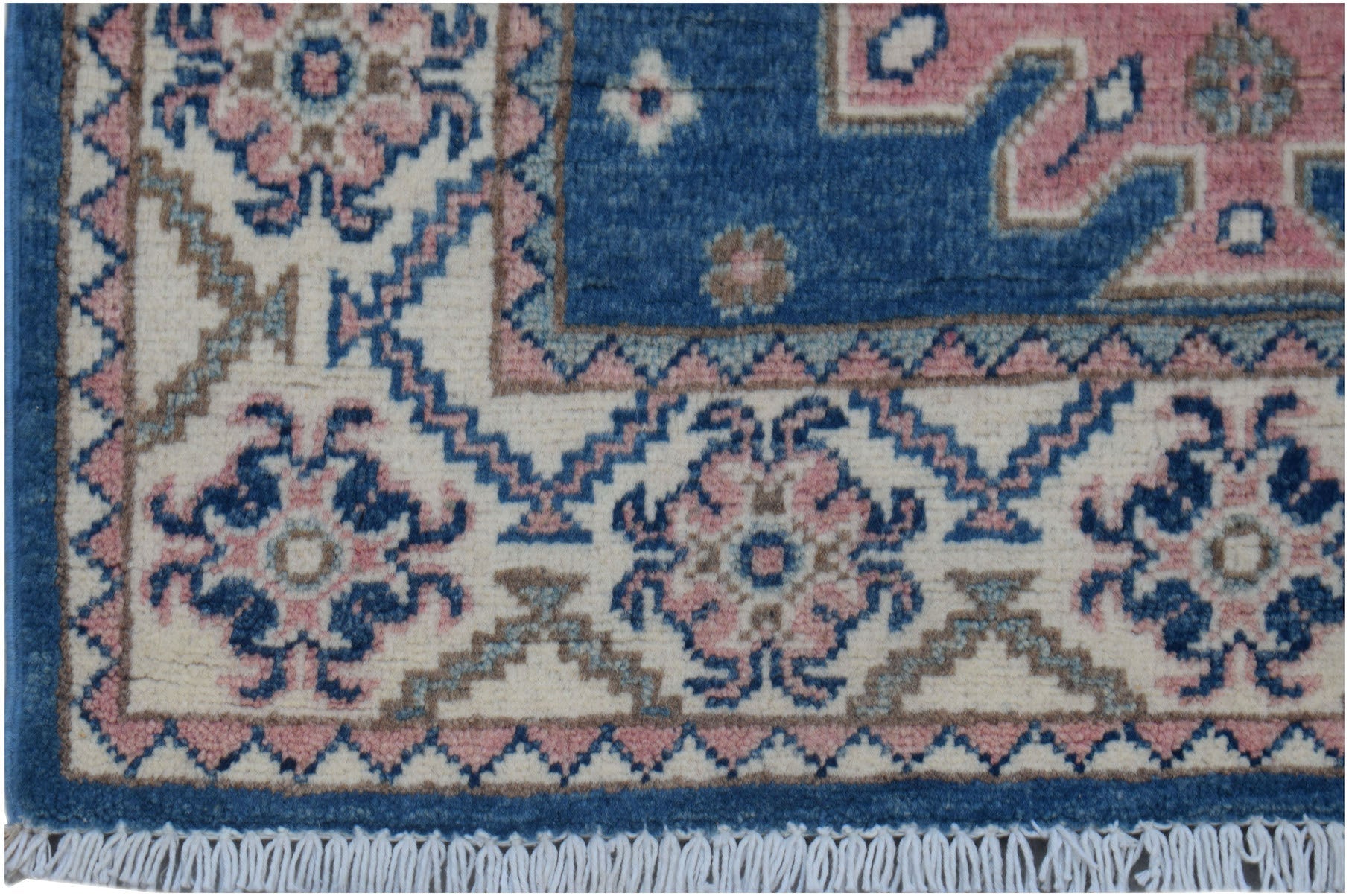 A handmade Afghan Kazakh runner featuring traditional floral motifs in blue, pink, and cream.