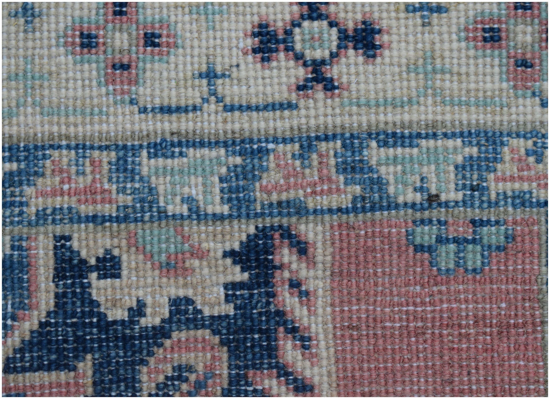 A close-up of a handmade Afghan Kazakh runner featuring traditional geometric motifs in wool.